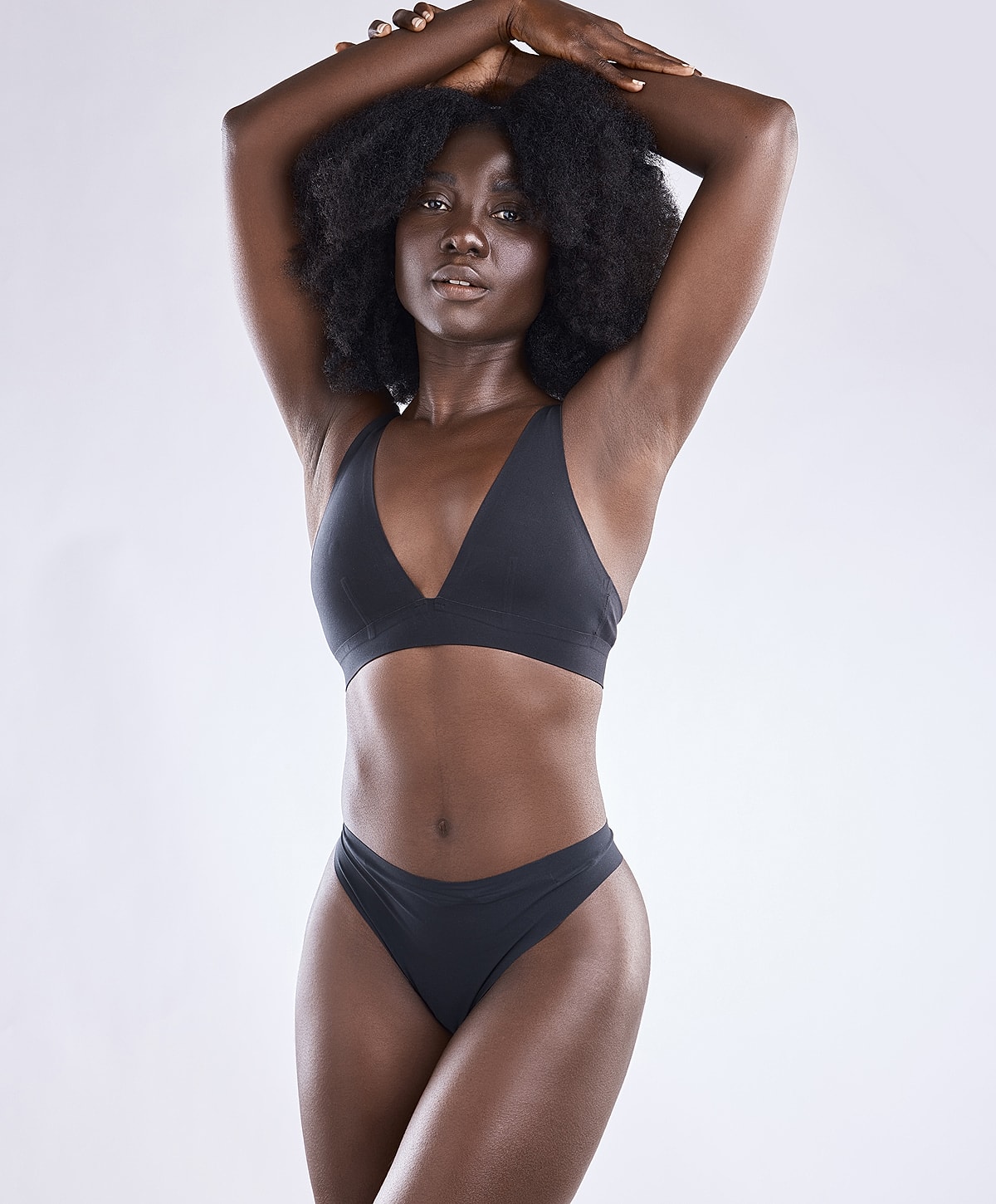 Model in black swimsuit posing confidently.