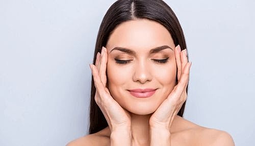 Woman relaxing with hands on her face.