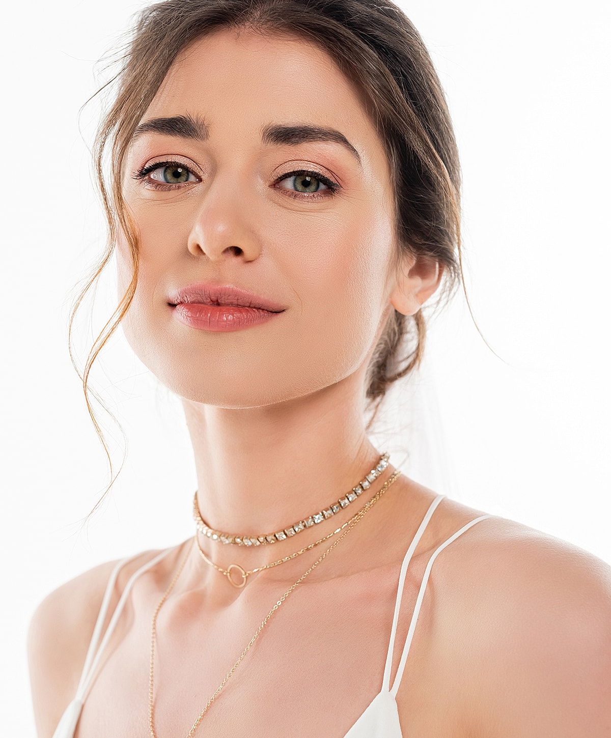 Woman with layered necklaces against white background