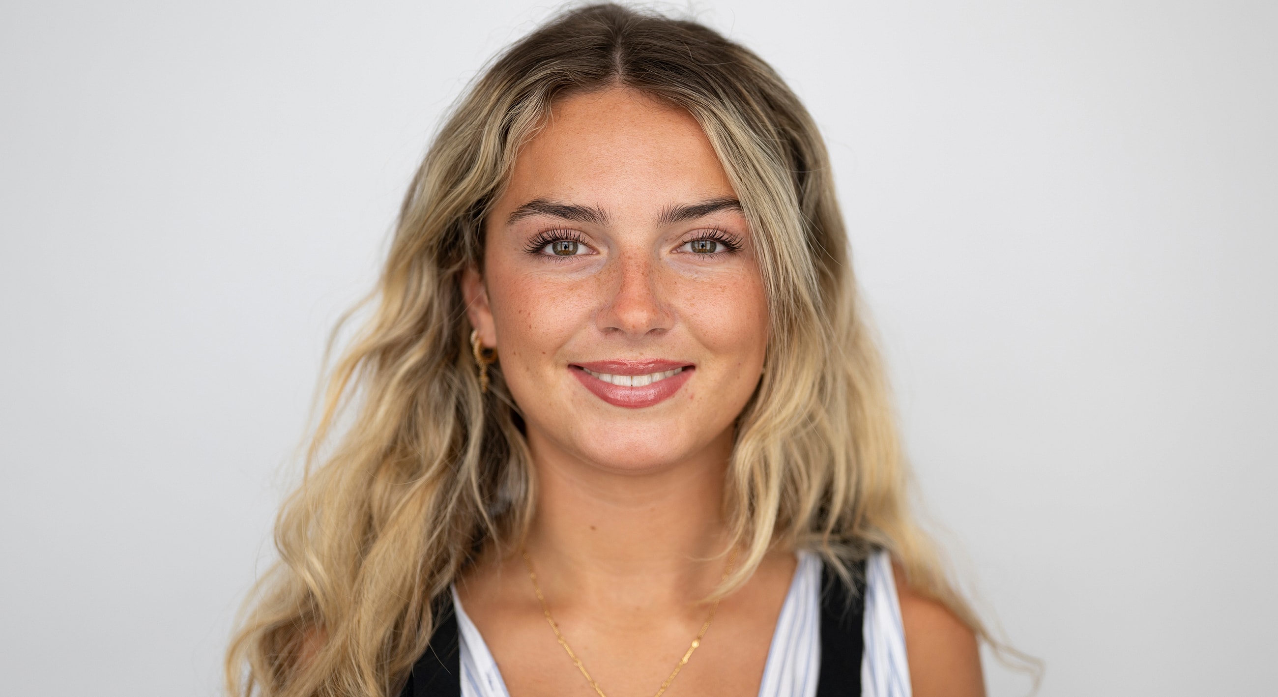 Smiling young woman with long wavy hair.