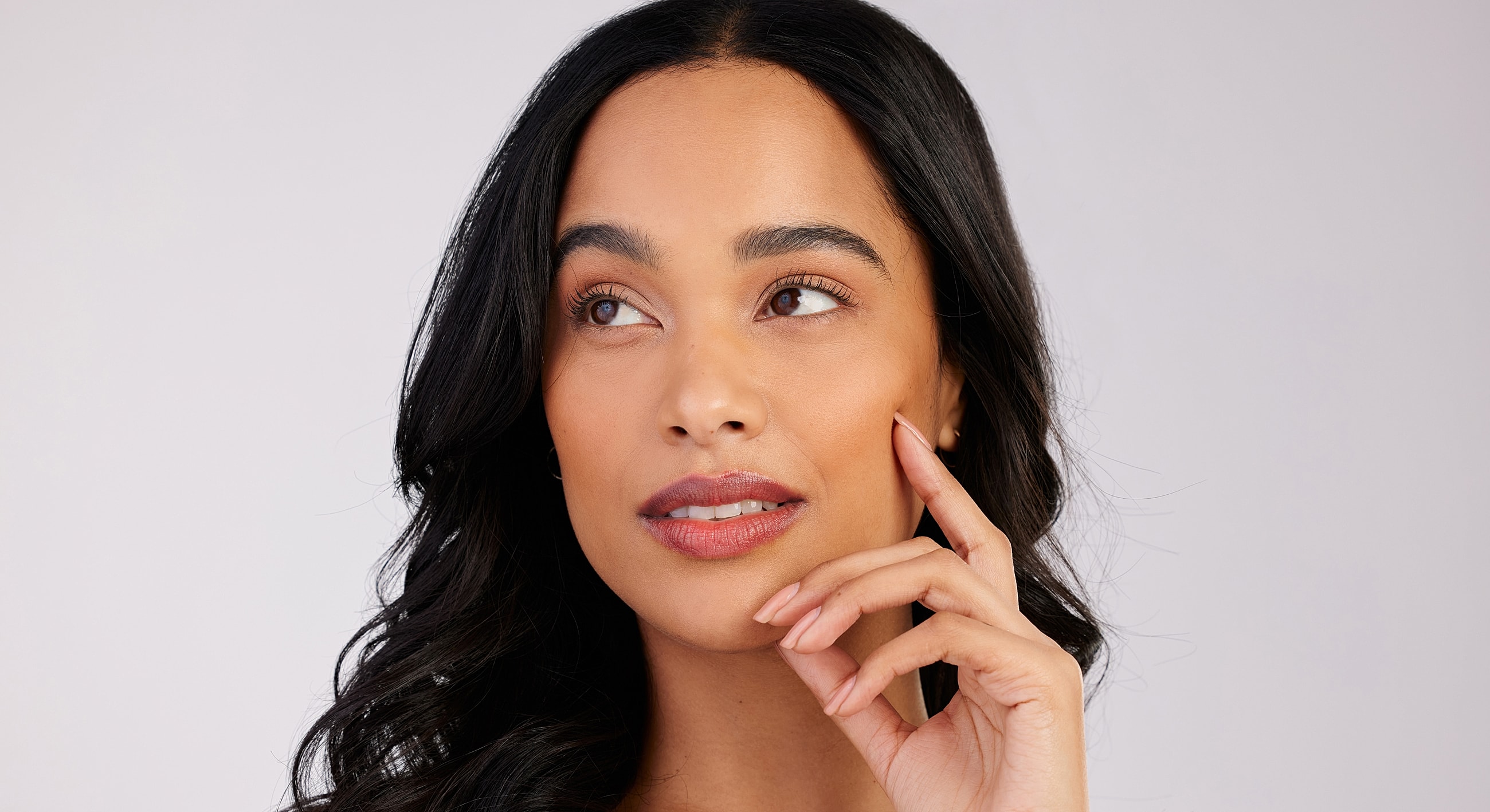 Woman with long hair contemplating thoughtfully.